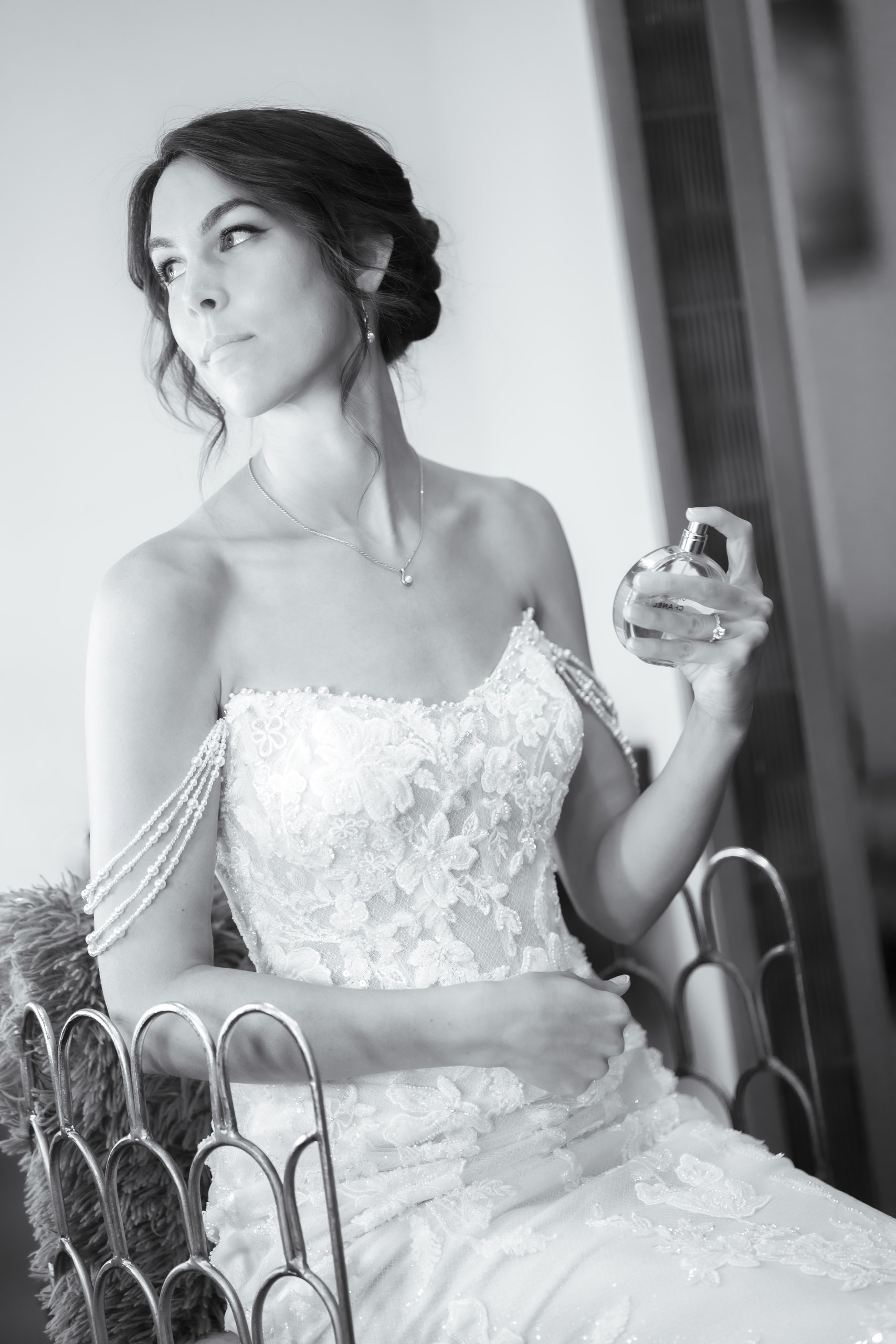 A bride seated with perfume in black and white